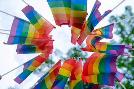 bottom view lgbtq rainbow flags from people's hands of lgbtq community equality movement in the park,concept for LGBTQ happy pride month.selective focusの写真素材