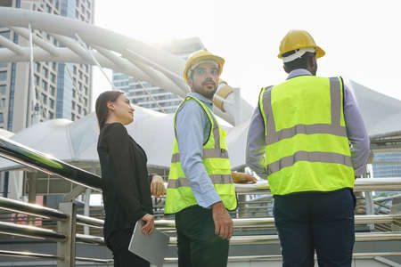engineers team are discussing while inspecting at construction site, multiracial business engineering man and woman are working outdoors in the urbanの写真素材