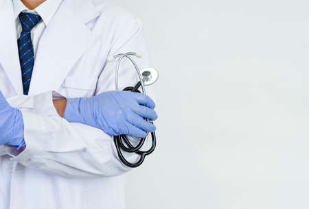 doctor hands arm crossed wear gloves and holding stethoscope with copy space, concept for health care, medical careの写真素材