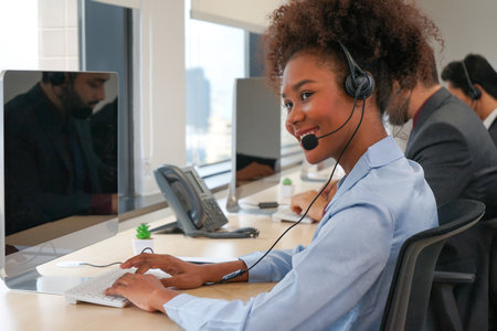 portrait the african american female wear headsets is working in a call centre, business woman operator agent is answering phone onlineの写真素材
