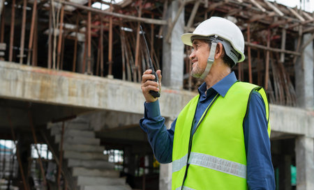 engineer using walkie-talkie communicate with worker at construction site