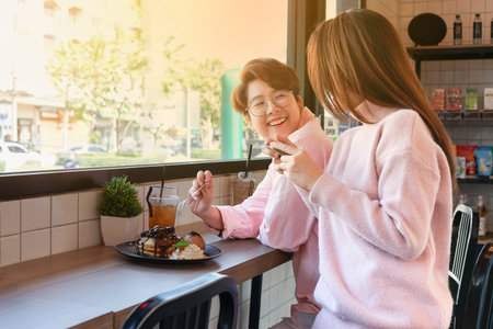 the romantic lgbtq lesbian lover in sweet pink dresses having sweets and beverage at the coffee bar...