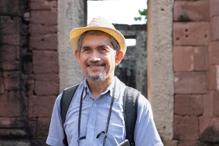 portrait asian senior man travelling at archaeological siteの写真素材