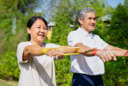 happy senior couple doing elastic band exercise, concept stretch exercise for rehabilitation muscles in older adultの写真素材
