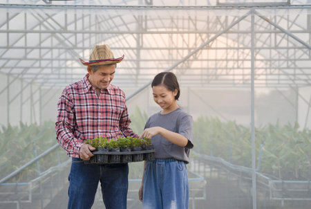 grandfather explained granddaughter to know the trees that he planted at greenhouse, concept family relationship, lifestyleの写真素材