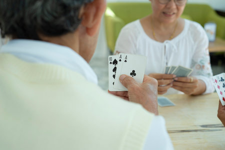group of seniors joyful playing cards at home, concept elderly people lifestyle, hobbies, relaxation,relationship. selective focusの写真素材