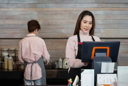happy asian female wears apron working at cash register counter, young successful woman coffee business owner, SME businessの写真素材