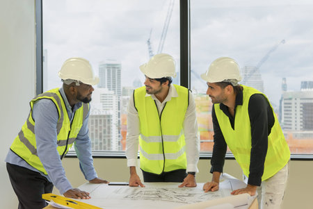 multiracial engineer or architect team meeting indoor building with construction plan,engineer...