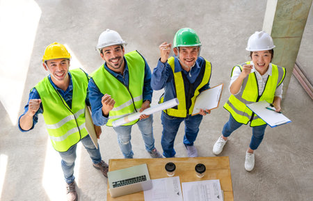top view the diverse engineers team standing,smiling and doing hand fist while meeting in the...
