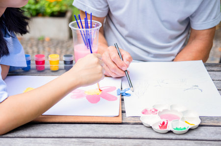crop shot teenage girl enjoy painting with grandpa in the summer garden, concept family lifestyle, activity together, relationship,raising teen, the love of a familyの写真素材