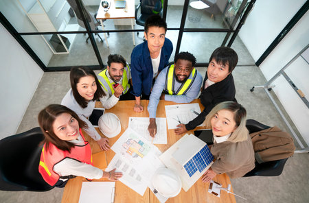 top view of multiracial engineers and architects team discussing, brainstorming with blueprint on...