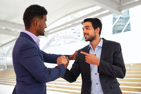 multiracial business colleague doing hands shake to greeting outside building,concept business people lifestyle,friendship,relationshipの写真素材