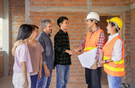 young man handshaking with a builder to build a new house, happy asian family,father,mother,adult...