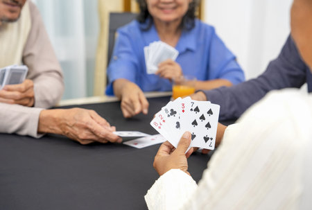 group of active senior pensioners playing cards game together, concept elderly retired people entertainment,recreation,encourages social interaction,help memory retentionの写真素材