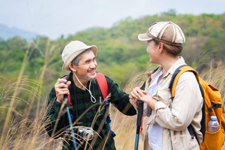 active asian senior couple hiking together on summer time,they are look at each other and smiling,concept of elderly pensioner lifestyle,family relationship,activity,travel,adventure in natureの写真素材