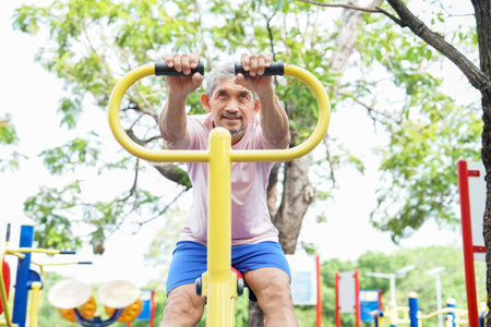 portrait healthy senior man enjoy exercise on stretch machine,mature man workout outdoors in the parkの写真素材