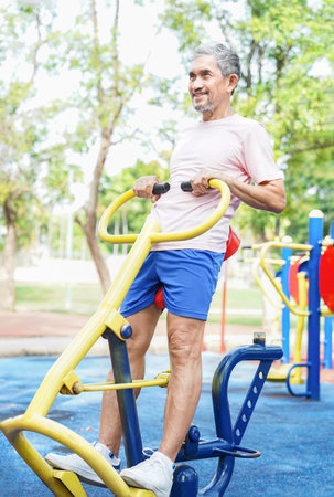 healthy senior man enjoy exercise on stretch machine,mature man workout outdoors in the parkの写真素材