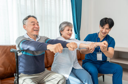 a young male assistant in uniform advice and help asian senior couple arm stretch exercise in the room,health care worker nurse visit at patient home,concept of elderly care,home careの写真素材