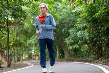 asian senior man running along the street in the park,elderly lifestyle,exercise,athlete