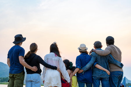 back view group of family and friends standing by the river,looking forward to the beautiful sunset...