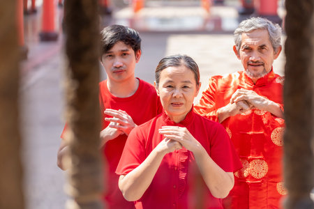 People praying and making wishes at an incense pot in shrine during holiday celebration and Chinese New Year traditional festivitiesの写真素材