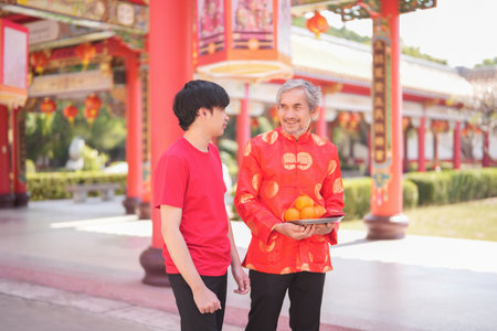 portrait asian family,father and young adult son with worship things in chinese shrine,concept for holiday celebration,chinese new year traditionalの写真素材
