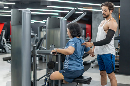 asian female with prosthetic leg doing fitness exercise with personal trainer at indoors fitness gym
