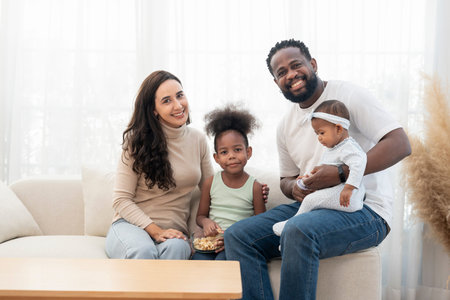 scene of bonding interracial family spend free time together in the living room,cozy home,domestic...