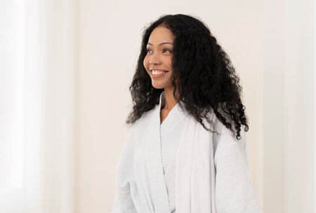 portrait young attractive mixed race black asian female in white bathrobe at spa room,woman beauty,body care,healthの写真素材