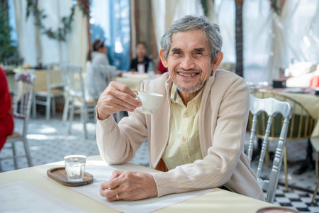 portrait smiling senior man enjoying a cup of coffee at restaurant,elderly lifestyle,holiday,relaxationの写真素材