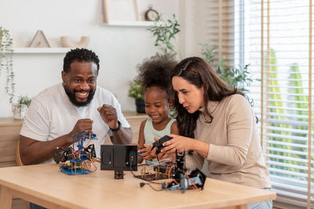 family having fun,parents help kid learning robot circuit,electronic board cable in STEM subject,concept family lifestyle,adult help kid,homeschoolingの写真素材