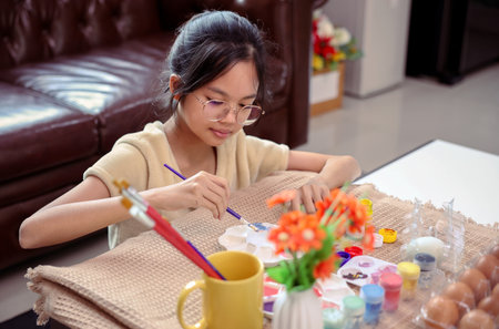 A girl paint eggs for easter celebration at home,traditional seasonの写真素材