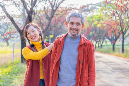 portrait of senior father and a young adult daughter spend holiday time travel together,exploring in nature at countryside in fall seasonの写真素材