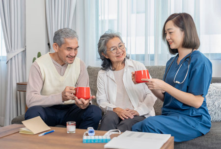 home health care nurse in uniform explain and advice healthy drink,fruit juice or vitamins while visiting senior couple at homeの写真素材