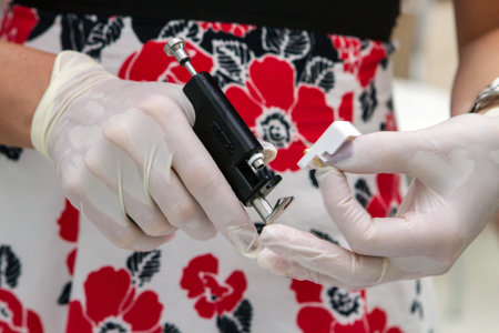 Hands in sterile gloves with a gunの写真素材