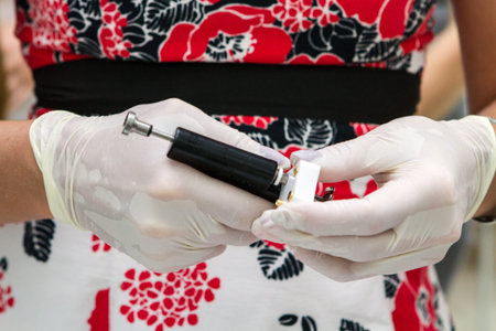 Hands in sterile gloves with a gun
