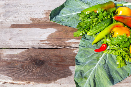 Fresh vegetables and herbs on a wooden board.