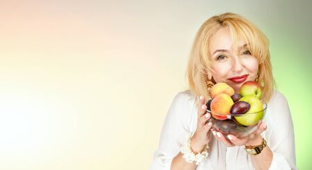 Adult woman with fruit in a bowl.の写真素材