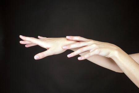 Female hands on a dark background.の写真素材