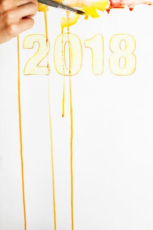 A person is painting a calendar for 2018 year.の写真素材