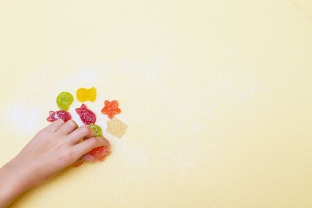The child arranges marmalade figurines in a marine style.の写真素材