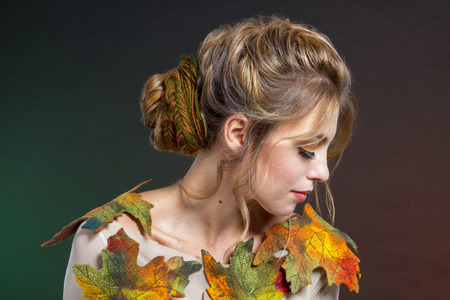 Beautiful woman with multi-colored maple leaves.の写真素材