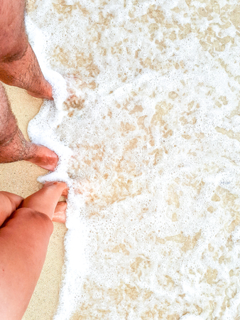 Tanned man's and female feet.の写真素材