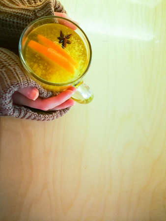 A cup of sea buckthorn tea is in the hands of a woman.の写真素材