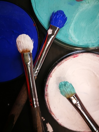 Artistic paints and brushes on a black background.の写真素材