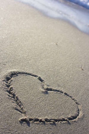 the symbol of a heart in the sand at sunsetの写真素材