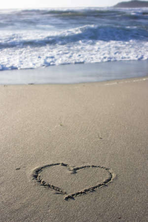 the symbol of a heart in the sand at sunsetの写真素材