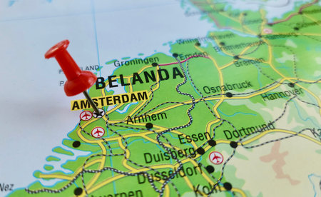 View of Amsterdam, is the capital and largest city of the Kingdom of the Netherlands, on a geographical map of Europe, marked with red pushpinの写真素材
