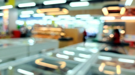 Blurred background of a supermarket interior with shelves and refrigerators filled with products