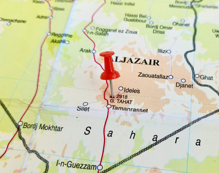 View of Mount Tahat, is the highest mountain in Algeria, on a geographical map of Africa, marked with red pushpinの写真素材